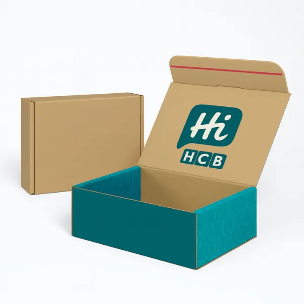 Kraft and teal mailer boxes - one plain brown- one with teal geometric sides and Hi HCB branding inside the lid- class=