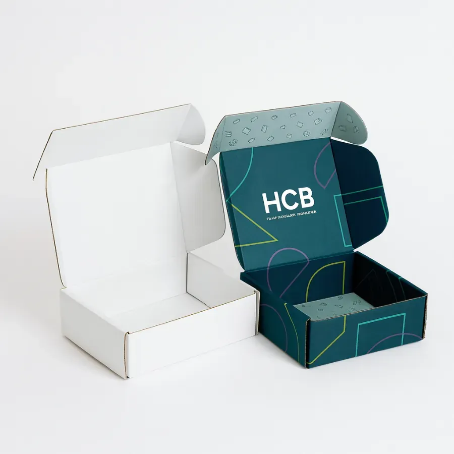 wo open cardboard mailer boxes- One is plain white- and the other is dark teal with geometric graphics and an -HCB- logo on the inside flap class=