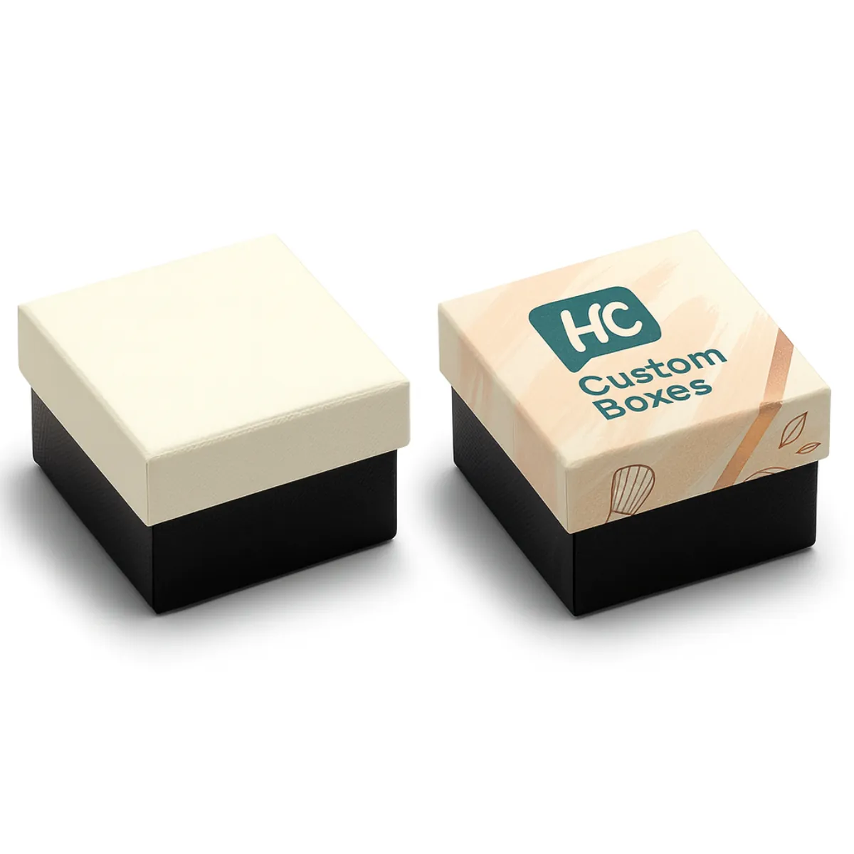 Two square rigid boxes for cosmetics packaging- One is plain cream with a black base- while the other is custom-printed with -HC Custom Boxes- logo and a soft peach design on the lid- class=