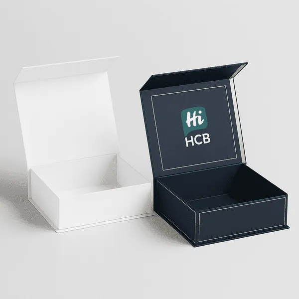 Two luxury magnetic rigid boxes one plain white and one navy blue with gold trim and HCB branding