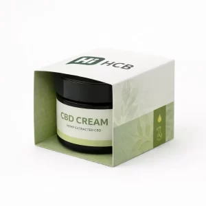A close-up of a black glass CBD cream jar enclosed in a green botanical-themed cardboard sleeve