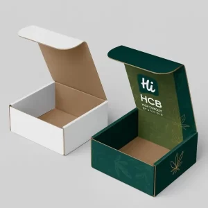Printed CBD subscription boxes in an open mailer style. One is white on the outside, and the other features a dark green exterior with a gold cannabis leaf logo and a matching internal brand print.