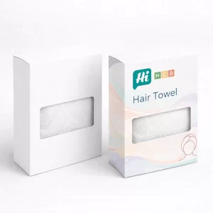 Two upright white boxes with rectangular cut-out windows showing the texture of a white hair towel.