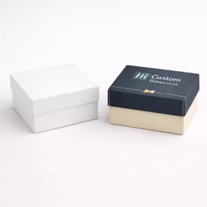 Two premium two-piece square gift boxes with lids, shown in white and branded navy blue.