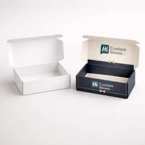 Two open cardboard mailer boxes showcasing a plain white interior and a branded navy design.