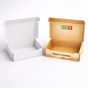 An open white cardboard mailer box next to a brown printed box featuring the HCB logo.