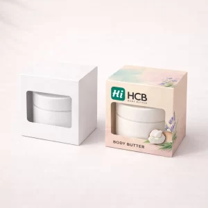 Two white retail cartons with cutout windows, one plain and one showing pink body butter branding.