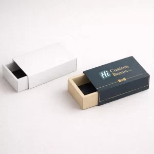 Two sliding drawer-style matchbox gift sets in plain white and branded navy blue colours.