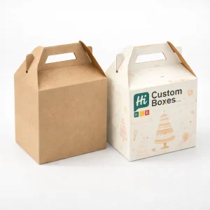 Two gable-style cake boxes with carry handles, one plain brown and one with colourful branding.