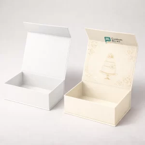 Open luxury rigid wedding cake boxes in white and cream with premium magnetic closures and elegant gold-foiled illustrations.
