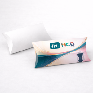 A white pillow-shaped box beside a custom-printed version with a teal logo and a shaper silhouette.