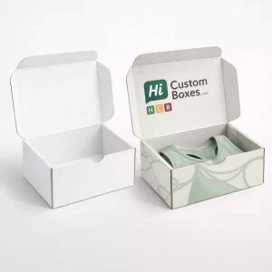 wo small white mailer boxes, one open to show a folded pale green bralette inside.
