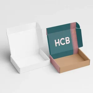 Two open mailer-style shirt boxes- one plain white and the other printed with teal and pink design featuring -HCB- branding- showcasing interior space for folded apparel