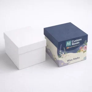 Two square wax melt gift boxes, one plain white and one featuring navy floral branding.