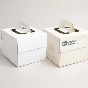 Square white and cream wedding cake packaging boxes featuring integrated carry handles and decorative pastel floral illustrations.