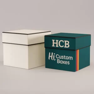 Two square rigid gift boxes one plain white with black trim one branded with HCB and colourful stripes