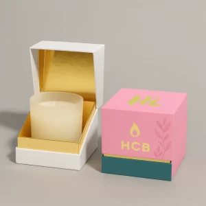 Two rigid candle gift boxes with lift-off lids, one plain white and one custom printed in cream, purple, and teal with HCB logo, candle flame, and decorative leaves.