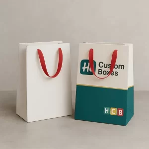 Two paper gift bags with red handles one plain white one custom printed with Hi Custom Boxes logo