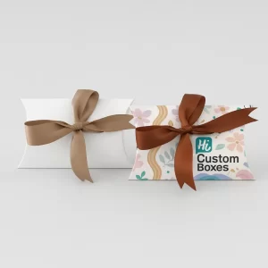 Two pillow boxes tied with brown ribbon- one white- the other with a pastel floral pattern