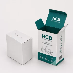 Plain white and branded teal cardboard counter display boxes with a rounded back for retail visibility.