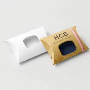Plain white pillow box alongside a metallic gold- ornate box with a square window showcasing dark fabric