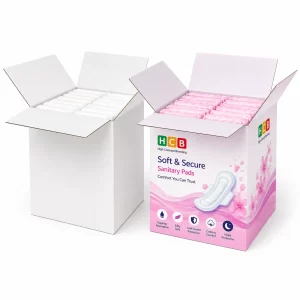 Two large open cardboard shipping boxes filled with rows of individually wrapped white and pink pads