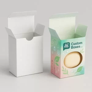 Two tuck end soap boxes- one plain white and one custom printed with pastel green and pink design- featuring a circular die-cut window and leaf graphics