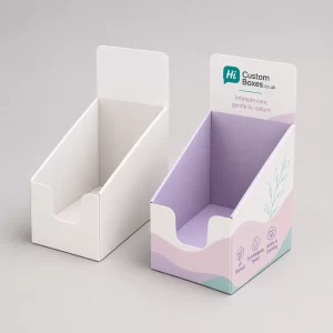 Two rectangular cardboard boxes, one plain and one with professional purple floral feminine care branding.